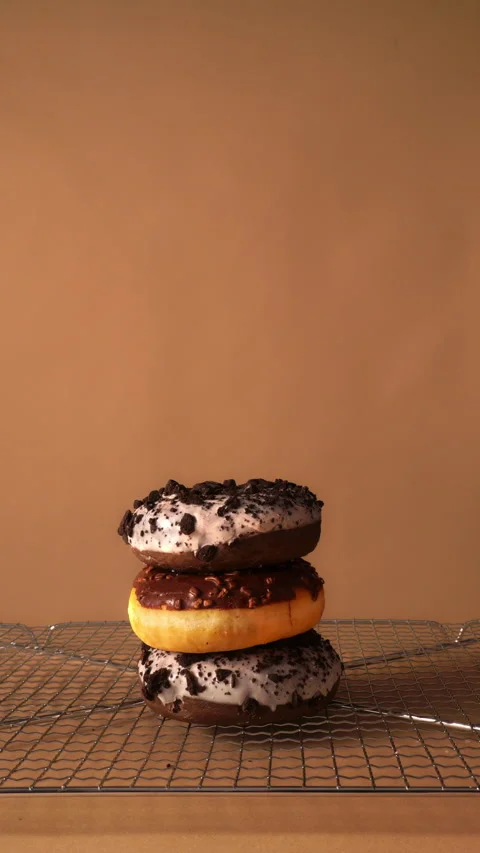 Hand Stacking Donuts One by One on Cooling brown beige Studio Background Stock Footage 331232752