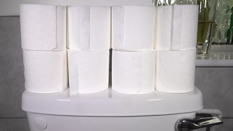 Hand stacking toilet rolls on cistern. Video stock 130385225
