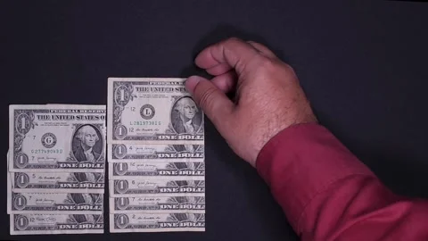 Hand stacks dollar bills simulating a growing bar graph in time-lapse Stock Footage 318557435