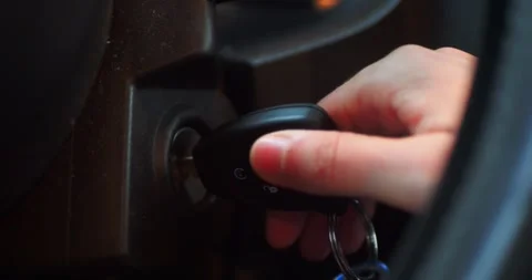 Hand starting a car by inserting a key into the ignition. Modern driving... Stock Footage 319882469
