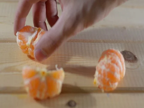 Hand steals from a tangerine table, close-up Stock Footage 121665076