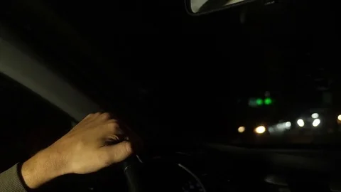 Hand on the steering wheel of the car. Evening night time. Left side traffic. 4k Video stock 82695176