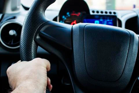 Hand on the steering wheel of a car. Stock Photos