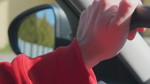 Hand on steering wheel, side mirror at car driving on street Stock Footage 126355232