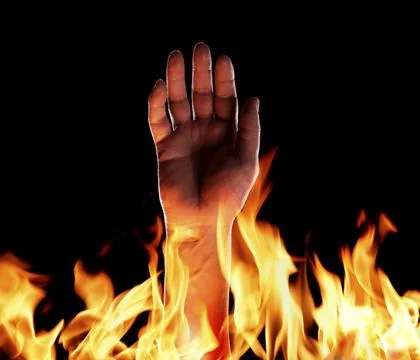 Hand sticking up from flames Stock Photos