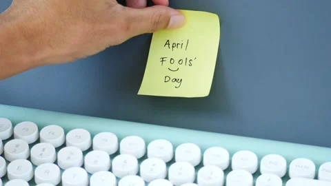 Hand sticking note with text April Fools' Day to the wall Stock Footage 269903625