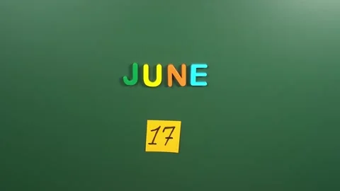 Hand sticking a sticker 17 June calendar day on school board. 17 date of June. Stock Footage 236428243
