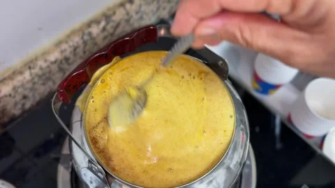 Hand Stirring Boiling Yellow Tea In Metal Teapot Stock Footage 345475280