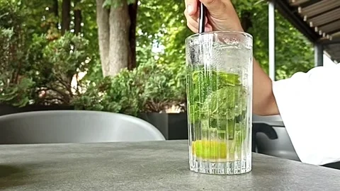 Hand Stirring Cold Mojito Cocktail with Lime and Mint Close Up Stock Footage 341736269