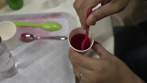 Hand Stirring Crimson Pigment Paste in a Paper Cup Stock Footage 340901140