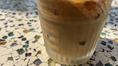 Hand stirring iced coffee with a straw Stock Footage 312014859