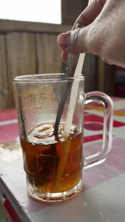 Hand stirring iced tea with a straw Stock Footage 327216115