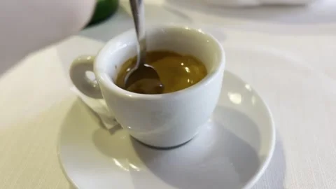 A hand stirring sugar in an espresso cup. Vídeo Stock 343885307