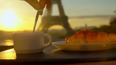 Hand stirs coffee in a cup with spoon against the backdrop of the Eiffel Tower Stock Footage 263034444