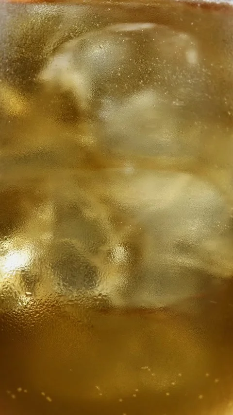 Hand stirs iced spiced cascara spritz in glass, mixing bubbles and orange Stockbeeldmateriaal 346265491