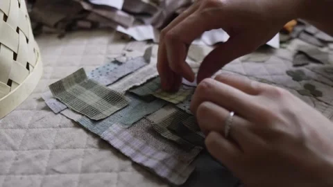 Hand stitching assorted small fabric patches together Stock Footage 315084837