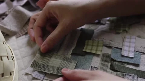 Hand stitching assorted small fabric patches together Stock Footage 315084846