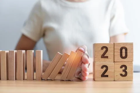 Hand stop falling blocks with 2023 year. Risk Management, recession, business Stock Photos