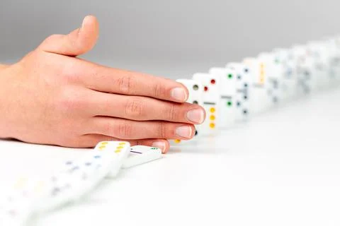 Hand stops dominos from falling. Plan and strategy in business Stock Photos