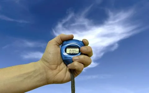 A hand with a stopwatch on a sky background Stock Photos