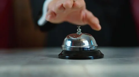 Hand strikes the bell on hotel reception Stock Footage