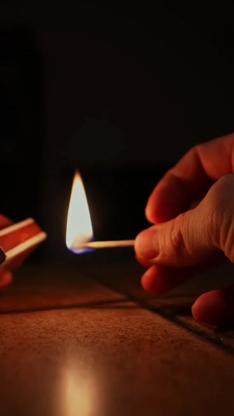 A Hand Strikes a Match in the Dark, Illuminating with a Warm, Gentle Glow Stock Footage 327447622