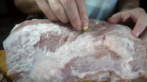 Hand stuffing meat with garlic in slow motion Stock Footage 139802282