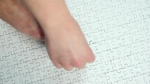 Hand successfully inserts correct puzzle piece into complex puzzle Piece of Stock-Footage 336248824