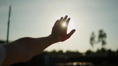 Hand to sun. Hand against the evening sky. Sunbeams shining through open fi.. Stock Footage 335596560