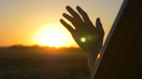 Hand at sunset. A man's hand from the window of a car in the sun's rays Stock-Footage 80036620