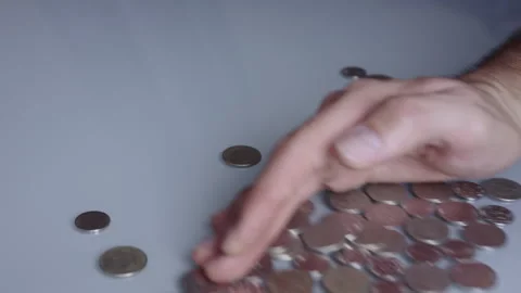 A hand sweeping coins off a table. Take the money from the profits. Video stock 267964713