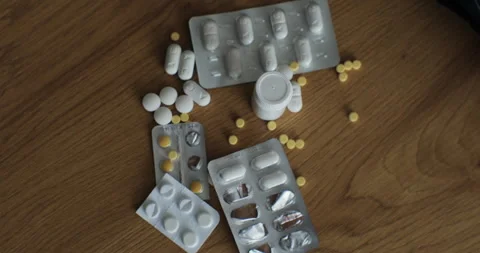 A hand sweeps a pile of pills from the table. Refusal of addiction. Top view Stock Footage 240219002