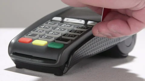 Hand swiping debit card through credit card terminal and entering PIN code Stock Footage 47864458