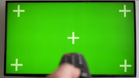 Hand switches the channels by remote control Flat screen TV with green screen Stock Footage 116655376