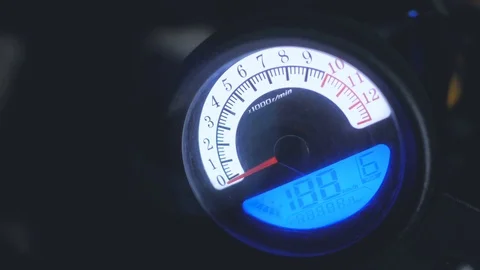 Hand switches on engine of motorcycle on control board by speedometer at night Stock Footage 83592252