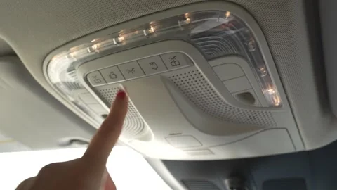 Hand switches on the interior light of a modern car Stock Footage 345171517