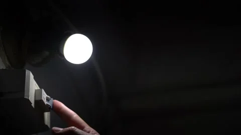 Hand switches turn off in position off light bulb goes out Stock Footage 156846520