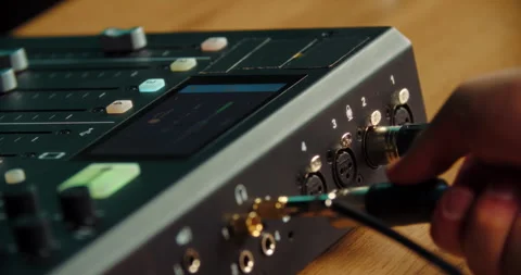 Hand switching audio cable between ports on sound mixer Stock Footage 316247513