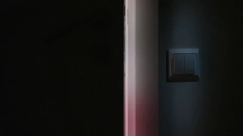 A Hand Switching On the Light in a Dark Room Stock Footage 82643431