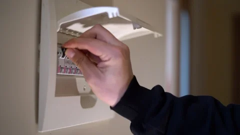 Hand switching power switch on a fusebox. Close up of electrician checking Video stock 125462186