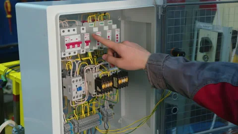 Hand switching power switch on a fusebox. Close up of electrician checking fuse Video stock 158979527