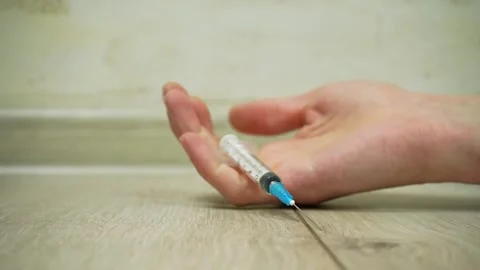 The hand with the syringe falls to the floor Stock Footage 236497785
