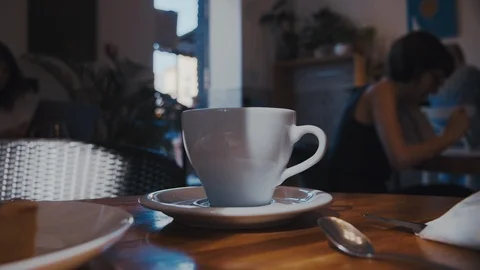 Hand take off and then put on plain white coffee cup on table in the cafeteria. Vídeo Stock 115551867