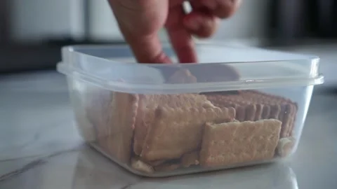 Hand take a crispy crackers from clear plastic Stockbeeldmateriaal 347685944