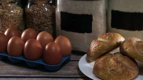 Hand take one egg from the table with buns, flour and oatmeal Stock-Footage 137645801