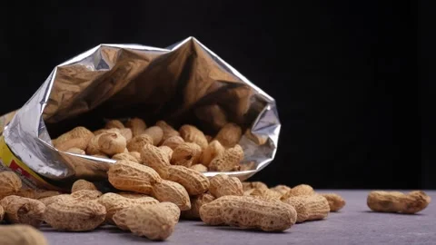 Hand take a peanut on the table isolated black background Stock Footage 275489413