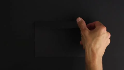 Hand take strange black envelope from black background, mysterious package Stockbeeldmateriaal 138890817