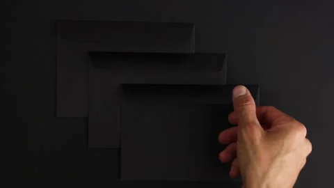 Hand take three strange blank black envelopes from black background Video stock 138890835