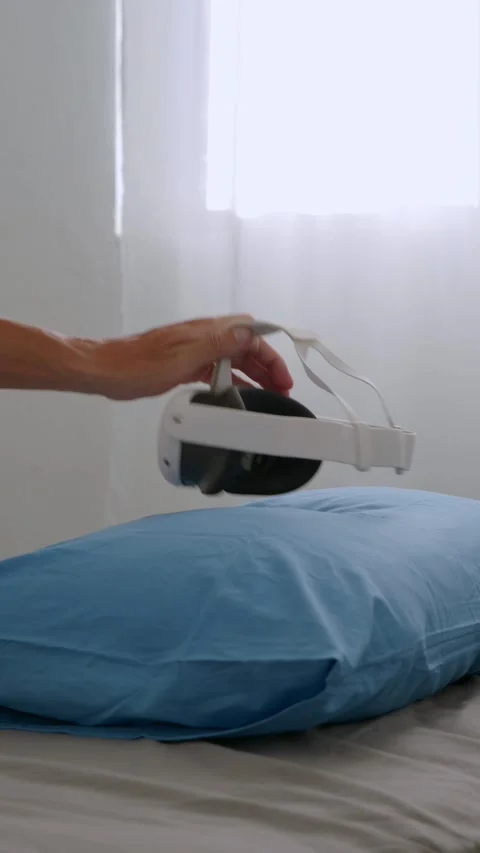 Hand take VR headset from pillow, on bed. Close-up. Stock Footage 279760293