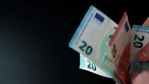 Hand takes 20 and 10 euro banknotes on black background with copy space Vidéo 331157530